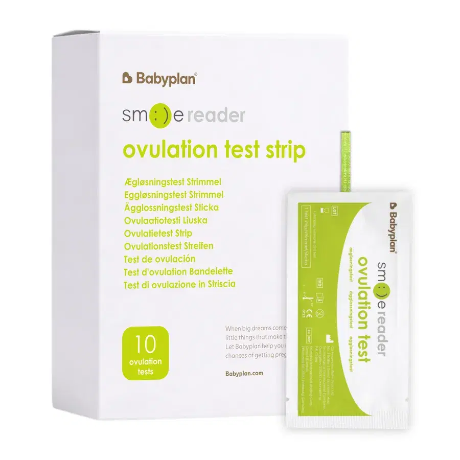 Hvit eske med Babyplan Smile Reader ovulation test strip og en grønn og hvit enkeltpakket test foran